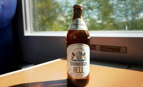Starnberger Hell Bierflasche steht auf einem Tisch im Zug.