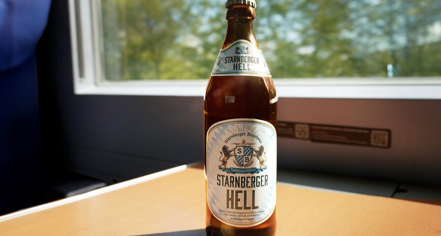 Starnberger Hell Bierflasche steht auf einem Tisch im Zug.
