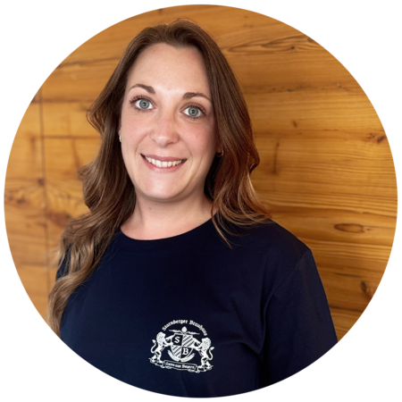 Frau mit braunen, langen Haaren, trägt ein dunkelblaues T-Shirt mit dem Starnberger Brauhaus Logo.