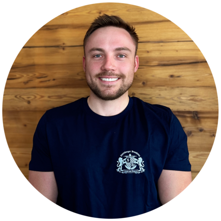 Junger Mann mit dunkelblonden, kurzen Haaren und einem Dreitagebart, trägt ein dunkelblaues T-Shirt mit dem Starnberger Brauhaus Logo.