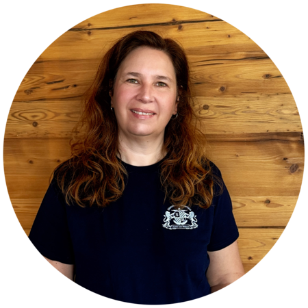 Frau mit braunen, lockigen Haaren, trägt ein dunkelblaues T-Shirt mit dem Starnberger Brauhaus Logo.