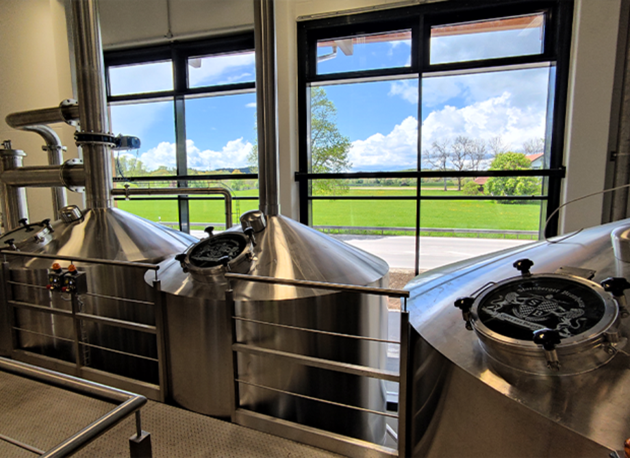 Drei silberfarbene Braukessel stehen nebeneinander im Starnberger Brauhaus.