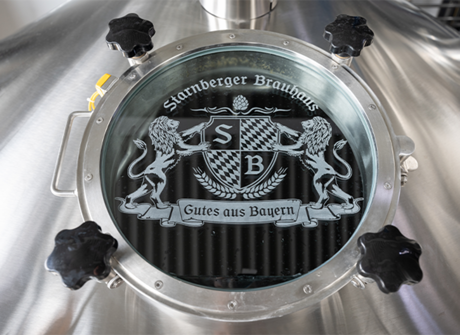 Rundes Fenster eines Braukessels mit dem Starnberger Logo drauf. 